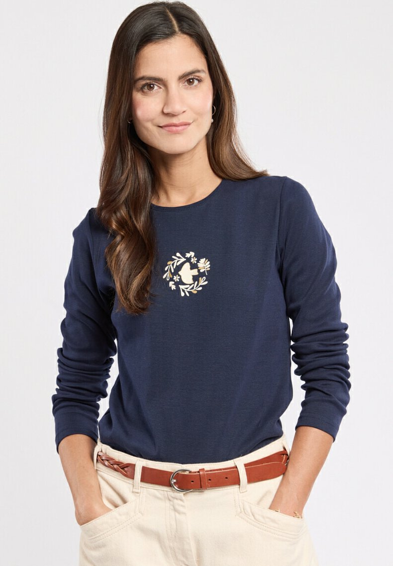 Marineblå skjorte med lange ærmer, der har et cremefarvet broderet blomsterkransdesign på brystet. Stoffet er glat, og skjorten har en regular fit.