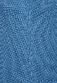 Blått stickat tyg med ett strukturerat mönster, med en fin väv och jämn färgfördelning. Lätt och flexibelt utseende.