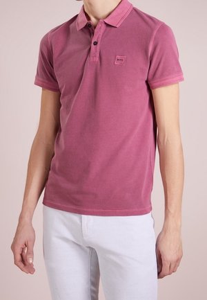 Kurzarm-Polohemd in gedämpftem Pink, aus weicher Baumwolle mit einem klassischen Kragen, ausgestattet mit einem kleinen Patch-Logo und zwei schwarzen Knöpfen.