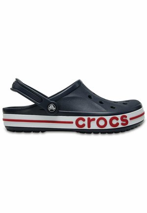 Marineblaue Freizeitschuhclog mit Lüftungslöchern, rot-weiß gestreifter Sohle und verstellbarem Fersenriemen.