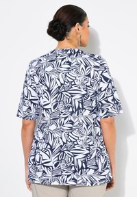 Námořnická modrá a bílá krátká halenka s listovým vzorem, zaobleným spodním lemem a volným střihem. Vyrobeno z lehkého materiálu.