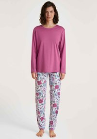 Langsleeve roze top gecombineerd met witte pyjamabroek met een bloemenpatroon in roze, blauw en groen. Zachte, lichte stof.