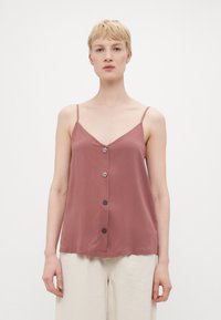 Top sin mangas color rosa con escote en V, que presenta una tapeta de botones en la parte delantera y finas tirantes. Tela suave, corte relajado.
