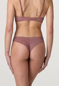 Completo reggiseno e perizoma in rete marrone con spalline regolabili. Texture liscia, design minimalista e senza dettagli hardware visibili.