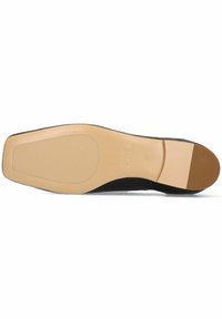Sole di scarpa nera con una finitura liscia e beige chiaro. Presenta un leggero tacco, una forma arrotondata e un dettaglio del nome del marchio embossato.