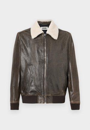 Chaqueta de cuero marrón con cuello de borreguillo, cierre frontal con cremallera, dos bolsillos laterales y puños y dobladillo acanalados. Textura suave, diseño informal.
