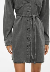 Sivi traper haljina s dugim rukavima, preklopom na gumbe, dva džepa na prsima i pojasom od tkanine, s ležernim krojem i ravnim rubom.