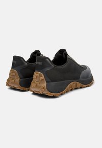 Scarpe da ginnastica nere in tessuto mesh, con accenti in gomma testurizzata e una suola robusta in gomma. Presentano un tallone imbottito per il comfort.