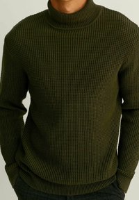 Pull en maille vert olive avec un col montant côtelé, un motif texturé et des poignets ajustés, conçu pour la chaleur et le confort.