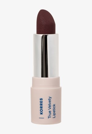 Rossetto True Velvety di Korres nel colore prugna scuro, racchiuso in un astuccio rosa e argento. Texture liscia con punta arrotondata per un'applicazione precisa.