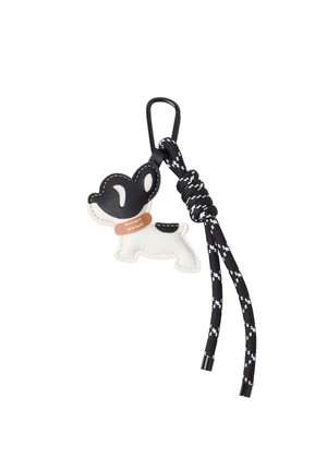 Nøglekæde formet som en sort og hvid hund med en tan krave, der er fastgjort til en sort og hvid flettet snor og en sort karabiner.