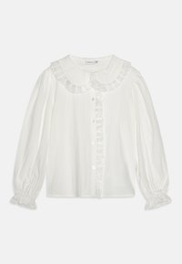 Hvit bluse med volangkrage, knapper foran og teksturerte ermer med elastiske mansjetter. Laget av lett materiale.