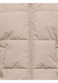 Sezione di giacca imbottita trapuntata beige con cerniera centrale e pannelli orizzontali cuciti.
