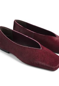 Chaussures plates bordeaux avec une finition lisse et brillante et un design à bout pointu. Fabriquées en matériau texturé, elles présentent un léger éclat et un style minimaliste.