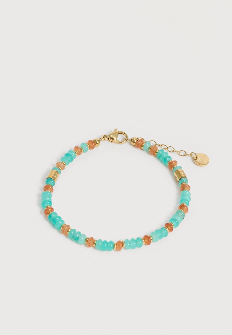 Βραχιόλι με χάντρες τυρκουάζ και κοραλλιών, χρυσά διαχωριστικά, κούμπωμα καβουράκι και ρυθμιζόμενη αλυσίδα με στρογγυλή χρυσή ετικέτα σε λευκό φόντο.
