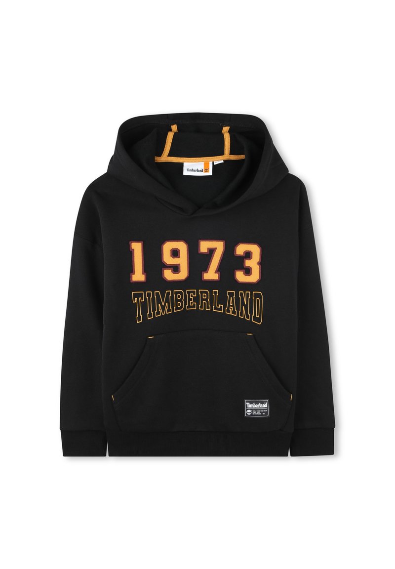 Un sweat à capuche noir avec une poche kangourou, des cordons orange et un texte jaune indiquant "1973 TIMBERLAND" sur le devant. Texture de tissu douce.