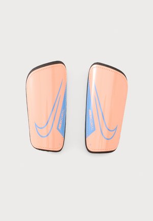 Paire de protège-tibias Nike Mercurial orange et bleu avec bords noirs sur fond gris clair.