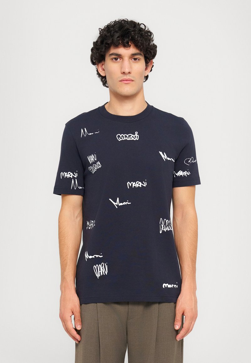 Marineblå bomulds t-shirt med hvide skrifttype-logoer trykt over det hele. Klassisk rund hals og korte ærmer, med en afslappet pasform.