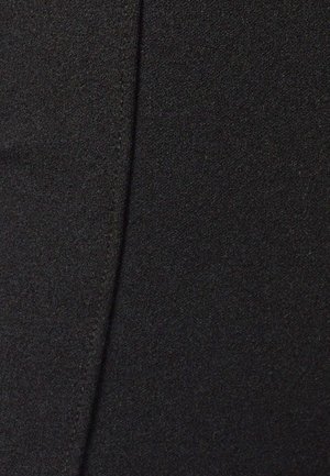 Tela negra con una textura suave que presenta un detalle de costura vertical, proporcionando una apariencia estructurada. Vista en primer plano de la superficie del material.