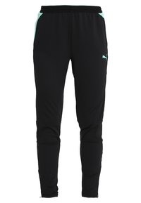 Svarta träningsbyxor i mjukt tyg har en tapered passform, elastisk midja och mintgröna detaljer längs sidofickorna.