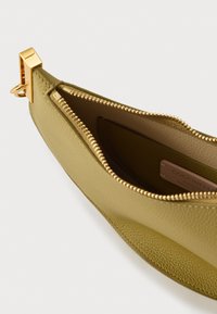 Etui na zamek w oliwkowo zielonej, teksturowanej skórze z elementami w kolorze złotym. Wnętrze jest gładkie, z widoczną metką marki.