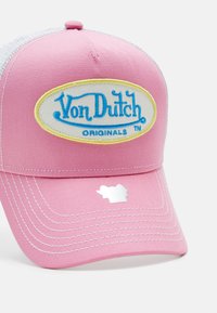Casquette de baseball rose avec un dos en maille blanche, arborant un grand logo ovale Von Dutch en bleu et jaune. Comprend des coutures blanches et des détails d'accent.
