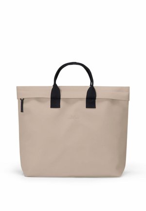 Beige tote bag with black fabric handles and zipper pull, rectangular shape, and subtle embossed branding on front.