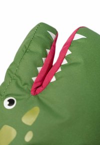 Grünes Dinosaurier-Plüschtier mit strukturiertem Oberflächenmaterial, rotem Inneren des Mundes, weißen Zähnen und schwarzen Augen. Verfügt über eine abgerundete, weiche Form.