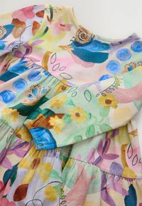 Robe florale colorée avec un col rond, des manches froncées et une jupe à volants. Présente des motifs de fleurs roses, violettes, jaunes et bleues sur un fond clair.