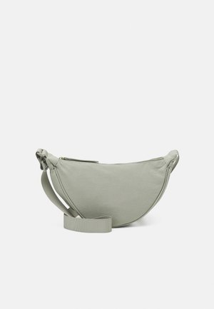 Sac bandoulière gris clair en forme de demi-lune avec sangle réglable et fermeture éclair, présenté sur un fond blanc uni.