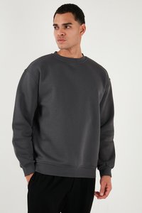Sudadera gris oscuro de tejido suave, con un cuello redondo y un corte relajado. Puños y dobladillo acanalados, diseño minimalista sin patrones.