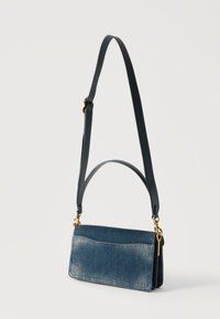 Ορθογώνιο τσάντα χειρός από τζιν με δύο σκούρες δερμάτινες λαβές, χρυσά μεταλλικά στοιχεία και ξεθωριασμένες λεπτομέρειες σε λευκό φόντο.