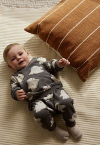 Hall halli beebiriiete komplekt kummitusemustritega, komplektis sobivad pusa ja püksid. Pehme kangas koos soonikkoeliste mansettide ja tekstuurse neutraalse taustaga.