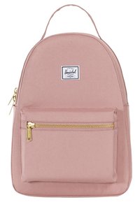 Jasnoróżowy plecak wykonany z płótna. O zaokrąglonym kształcie z przednią kieszenią na zamek. Posiada biały naszywkę z logo oraz złote elementy zamka.