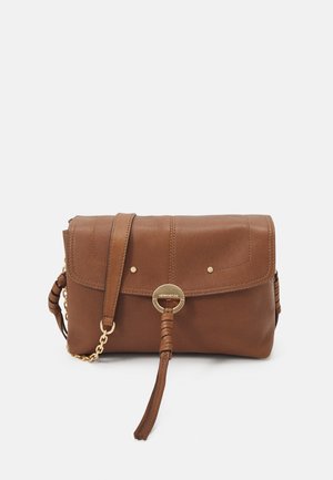 Brun læder crossbody-taske med flaplukning, guldring og kædedetaljer samt justerbar skulderrem mod hvid baggrund.