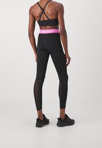Black sports leggings with a pink waistband, featuring a high waist, mesh panels on the lower legs, and a fitted design.