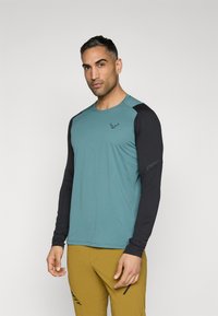 Langärmliges Sportshirt mit einem türkisfarbenen Körper und schwarzen Ärmeln. Verfügt über einen runden Halsausschnitt und ein kleines Logo auf der Brust. Weiche Textur.