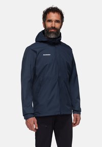 Navy blue waterproof jacket with a hood, featuring a front zipper, side pockets, and a subtle logo on the chest. Smooth texture.