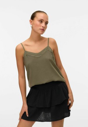 Olive green, sleeveless top with thin straps and a V-shaped neckline, paired with a black, layered ruffled skirt. Smooth fabric texture.