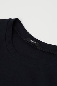 Námořnické bavlněné tričko s kulatým výstřihem, s texturovanou tkaninou a malou černou štítkovou nášivkou s názvem značky "TEZENIS" uvnitř.