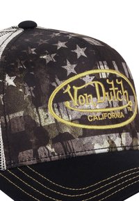 Casquette trucker noire et grise avec un logo brodé jaune "Von Dutch California" sur un fond étoilé à motifs.
