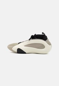 Lekki sneaker z czarną siateczkową cholewką, beżowymi i kremowymi akcentami oraz gładką gumową podeszwą z teksturowanym bocznym panelem.