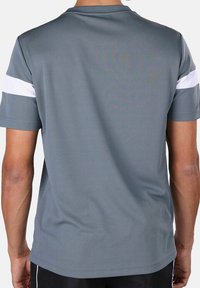Grijze sportshirt met een ronde hals en korte mouwen. Bevat witte strepen op elke schouder. Soepele, lichte stof.