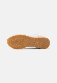 Zapatilla deportiva blanca con suela de goma texturizada. Dispone de una puntera reforzada, plantilla acolchada y parte superior de malla para mayor transpirabilidad.