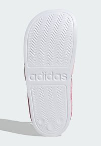 Suela de zapatilla Adidas en color rosa, con goma blanca y un patrón de agarre en zigzag, logo grabado y indicador de talla. Textura suave con bordes redondeados.