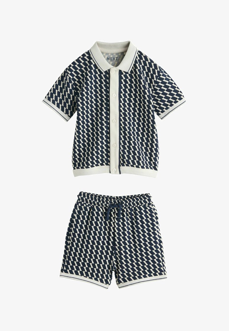 Súprava krátkymi rukávmi z rozopínacej košele a šortiek s elastickým pásom, vzorovaná námorníckymi a bielymi geometrickými tvarmi s krémovými ozdobnými detailmi.