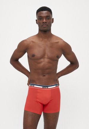 Röda boxerkalsonger med en figurnära design, tillverkade av mjukt tyg, med ett kontrasterande midjeband i vitt och marinblått med "Levi's"-logotypen.