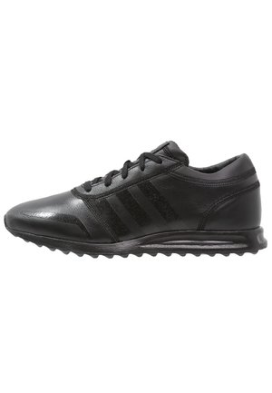 Czarny skórzany sneaker z sznurowaniem z przodu, trzema bocznymi paskami, amortyzowaną podeszwą i teksturowaną podeszwą zewnętrzną, pokazany w widoku bocznym.