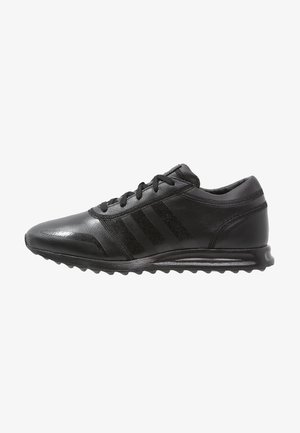 Czarny skórzany sneaker z sznurowaniem z przodu, trzema bocznymi paskami, amortyzowaną podeszwą i teksturowaną podeszwą zewnętrzną, pokazany w widoku bocznym.