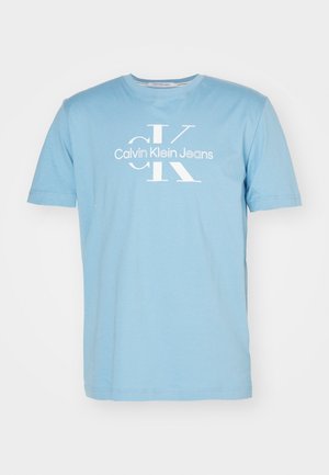 T-shirt in cotone azzurro chiaro con collo a giro, maniche corte, con un logo stampato bianco che recita "Calvin Klein Jeans" e un "CK" stilizzato.